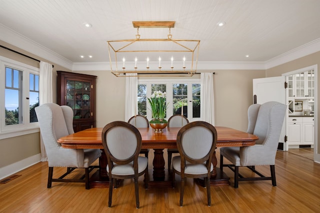 dining room with light wood-type flooring, wood ceiling, ornamental molding, and a notable chandelier