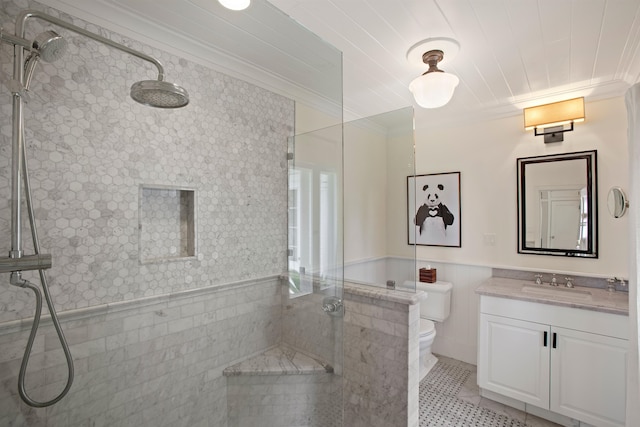 bathroom featuring ornamental molding, vanity, tiled shower, tile patterned flooring, and toilet