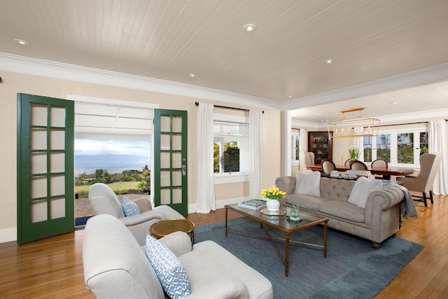 living room with hardwood / wood-style floors, wood ceiling, crown molding, and a wealth of natural light