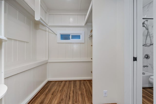 walk in closet with dark wood-type flooring