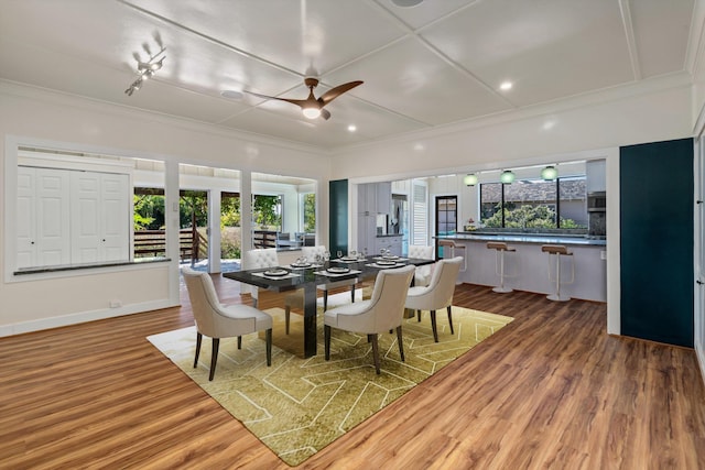 dining room featuring hardwood / wood-style floors, crown molding, and plenty of natural light