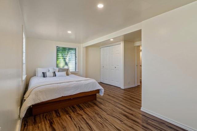 bedroom with dark hardwood / wood-style flooring and a closet