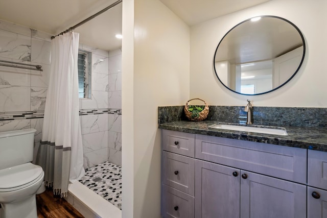 bathroom featuring vanity, curtained shower, wood-type flooring, and toilet