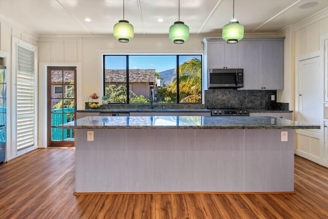 kitchen with decorative light fixtures, sink, gray cabinetry, dark stone counters, and range