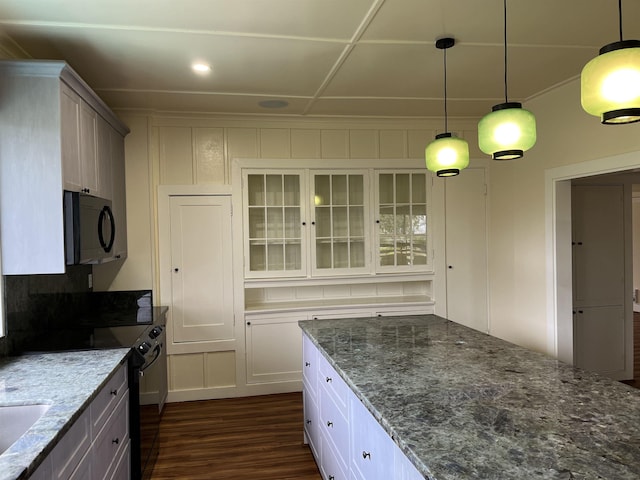 kitchen with decorative light fixtures, white cabinets, dark stone counters, and black appliances