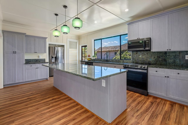 kitchen featuring sink, gray cabinetry, hanging light fixtures, a kitchen island, and stainless steel appliances