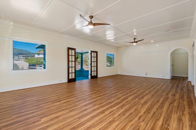 empty room with hardwood / wood-style floors, ornamental molding, and ceiling fan