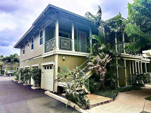 24 One Hali Ln Unit 7-203, Kihei, HI 96753 - view of side of property featuring board and batten siding, a balcony, and a garage