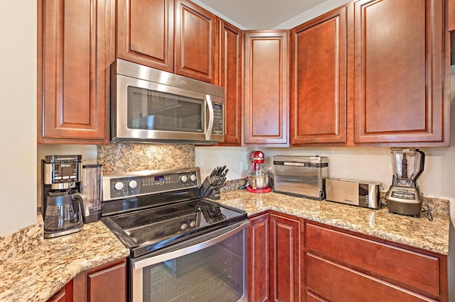 24 One Hali Ln Unit 7-203, Kihei, HI 96753 - kitchen featuring appliances with stainless steel finishes, light stone countertops, dark brown cabinets, and backsplash
