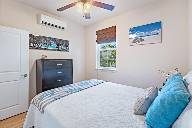24 One Hali Ln Unit 7-203, Kihei, HI 96753 - bedroom with a wall unit AC, light wood-style flooring, and ceiling fan