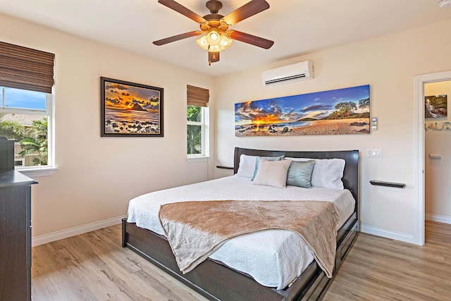 24 One Hali Ln Unit 7-203, Kihei, HI 96753 - bedroom featuring a wall mounted air conditioner, light wood-type flooring, baseboards, and ceiling fan