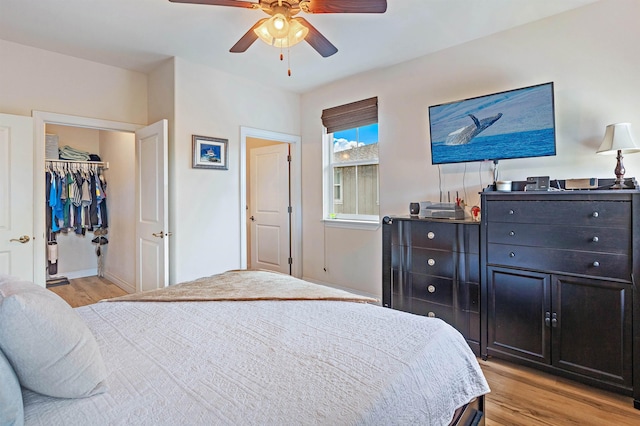 24 One Hali Ln Unit 7-203, Kihei, HI 96753 - bedroom with light wood-style flooring, a ceiling fan, and a walk in closet