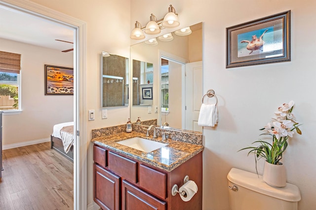 24 One Hali Ln Unit 7-203, Kihei, HI 96753 - bathroom featuring toilet, vanity, wood finished floors, baseboards, and connected bathroom