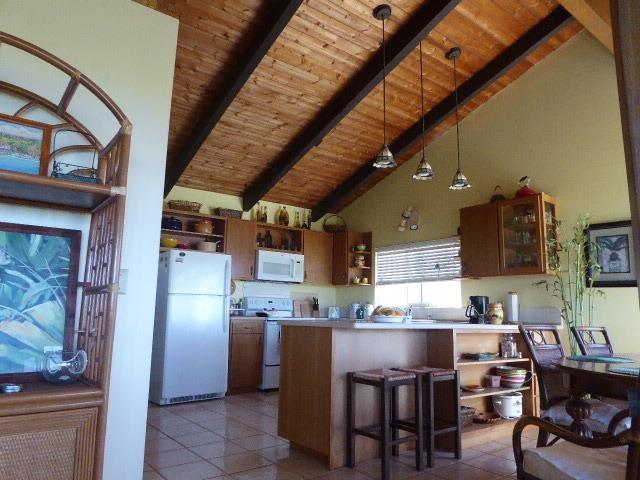 kitchen with decorative light fixtures, wooden ceiling, kitchen peninsula, beamed ceiling, and white appliances