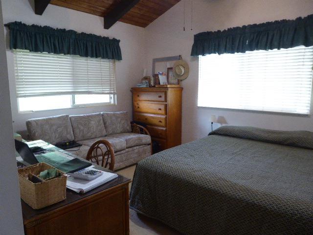 bedroom with vaulted ceiling with beams and wooden ceiling