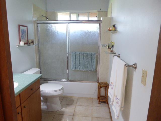 full bathroom with vanity, tile patterned floors, toilet, and combined bath / shower with glass door