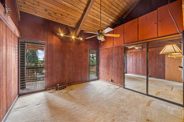 carpeted spare room featuring beam ceiling, wooden walls, high vaulted ceiling, and wooden ceiling