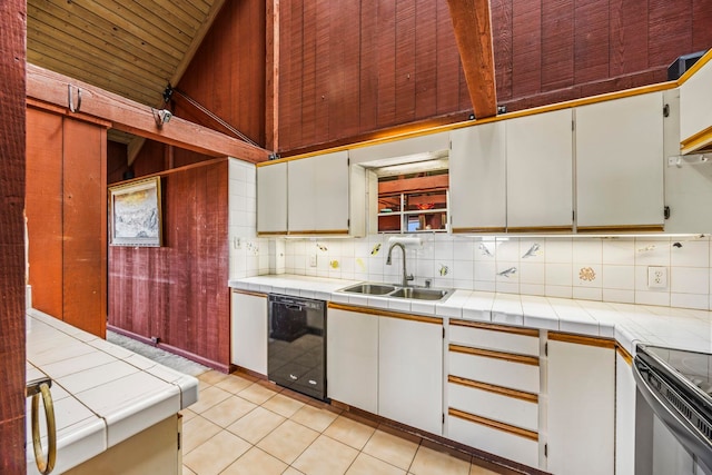 kitchen with tile countertops, sink, white cabinets, and black dishwasher