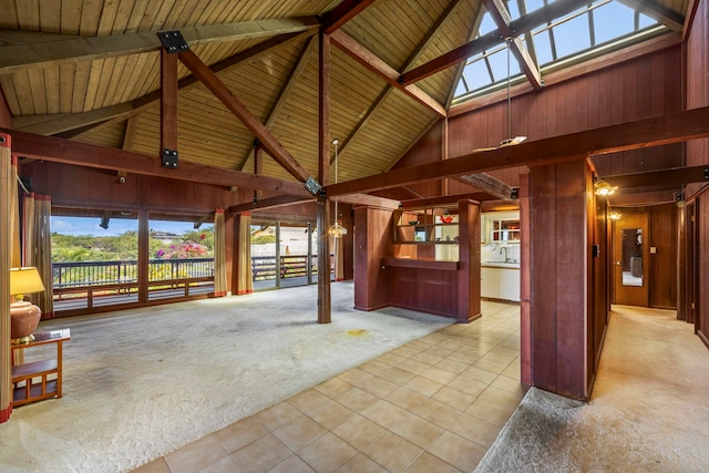 interior space with vaulted ceiling with beams, a healthy amount of sunlight, and wood ceiling