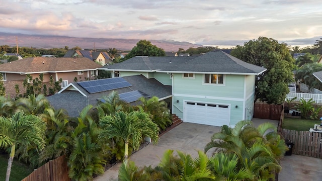 view of front of home featuring a garage and solar panels