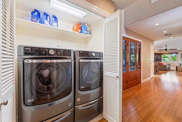 clothes washing area with independent washer and dryer, hardwood / wood-style flooring, and ceiling fan