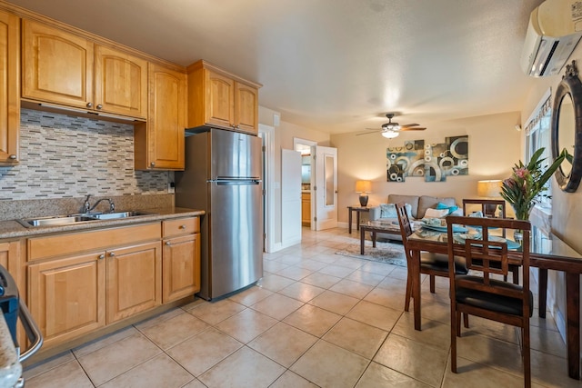 kitchen with an AC wall unit, tasteful backsplash, stainless steel fridge, sink, and ceiling fan