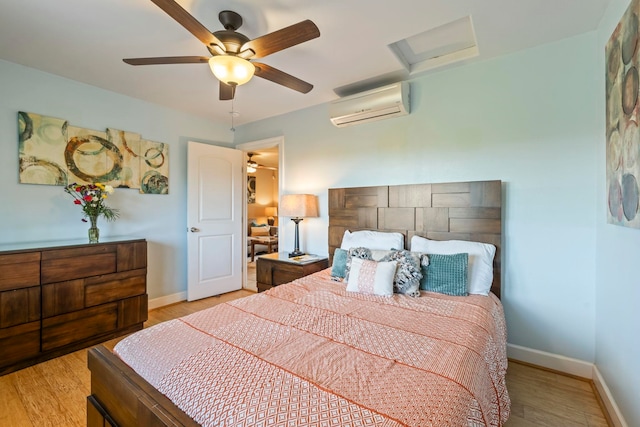 bedroom featuring a wall mounted AC, ceiling fan, and light hardwood / wood-style flooring