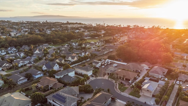 aerial view at dusk featuring a water view