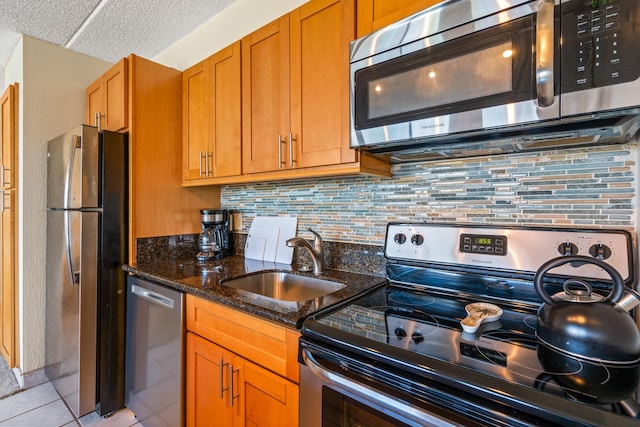 2495 S Kihei Rd Unit 248, Kihei, HI 96753 - kitchen with stainless steel appliances, a sink, decorative backsplash, dark stone countertops, and a textured ceiling
