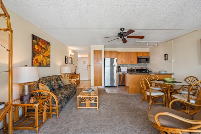 2495 S Kihei Rd Unit 248, Kihei, HI 96753 - living room featuring a textured ceiling, track lighting, a ceiling fan, carpet flooring, and tile patterned flooring