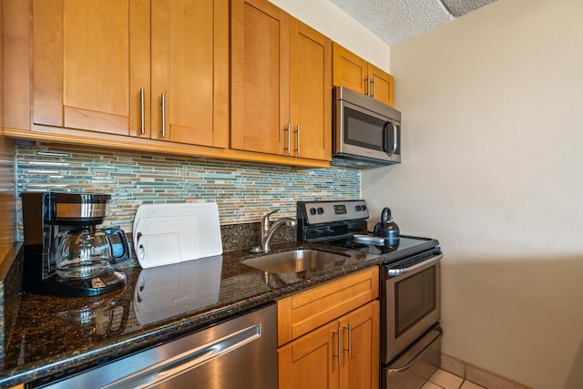2495 S Kihei Rd Unit 248, Kihei, HI 96753 - kitchen with stainless steel appliances, a sink, tasteful backsplash, dark stone counters, and brown cabinets