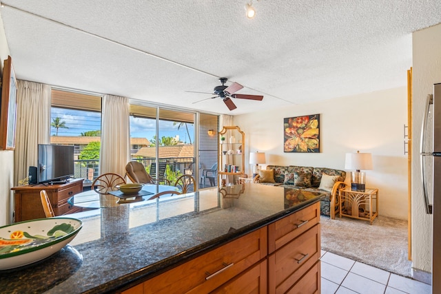 2495 S Kihei Rd Unit 248, Kihei, HI 96753 - kitchen with light colored carpet, a textured ceiling, a ceiling fan, light tile patterned floors, and open floor plan