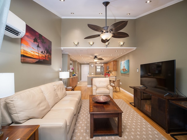 living room with ceiling fan, light wood-style flooring, baseboards, an AC wall unit, and crown molding