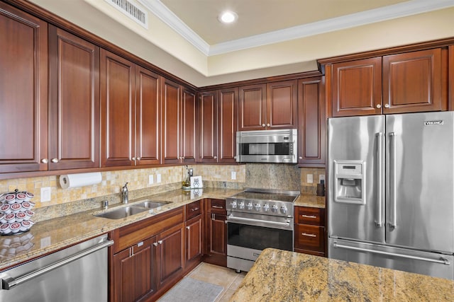 kitchen featuring decorative backsplash, premium appliances, ornamental molding, and a sink