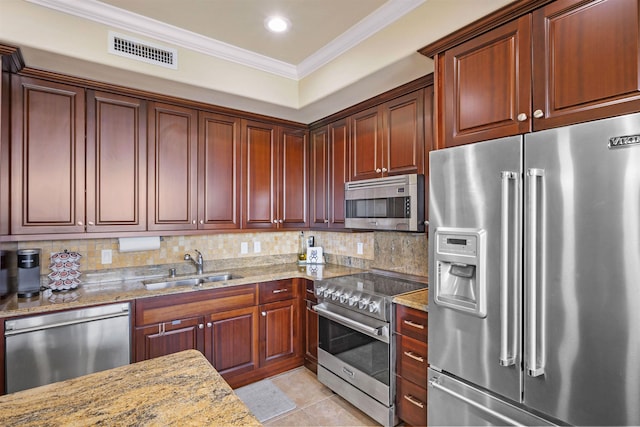 kitchen with visible vents, tasteful backsplash, a sink, ornamental molding, and premium appliances