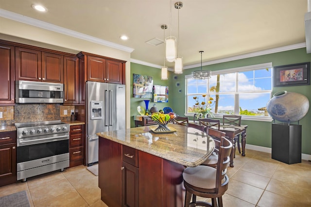 kitchen with light stone countertops, a center island, decorative backsplash, light tile patterned floors, and premium appliances