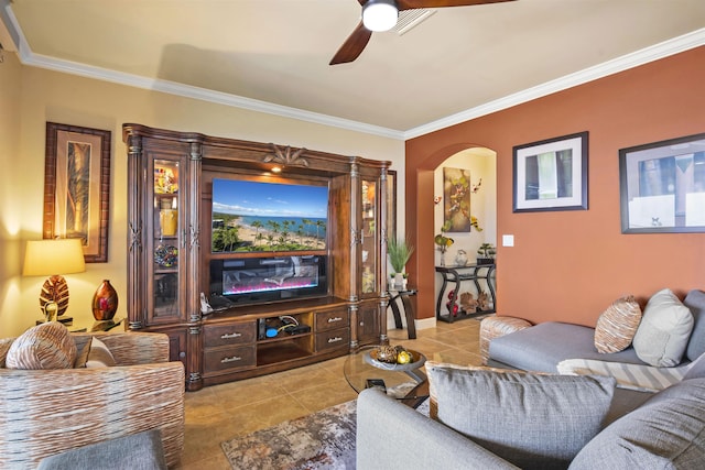 living room with crown molding, a ceiling fan, arched walkways, and light tile patterned floors