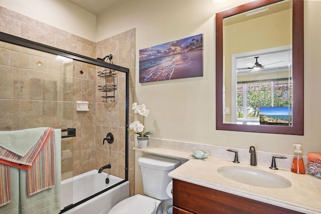 bathroom featuring toilet, ceiling fan, enclosed tub / shower combo, and vanity