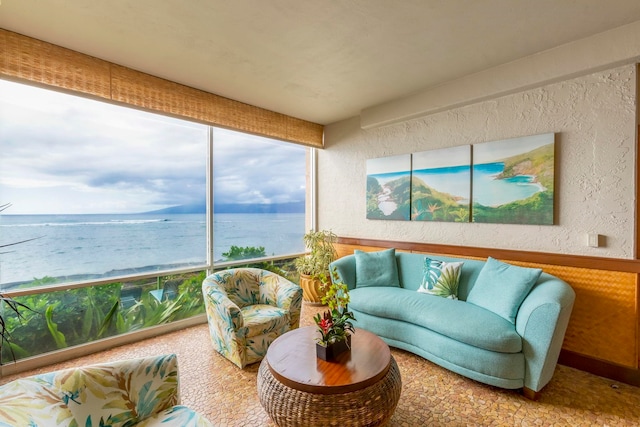 sunroom featuring a water view