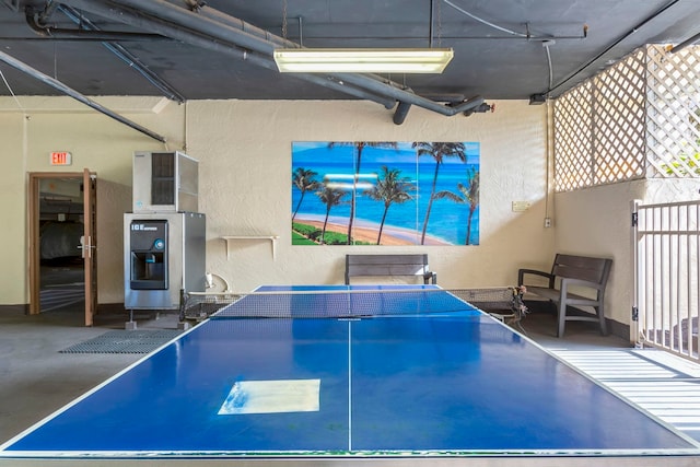 game room with a textured wall and finished concrete floors