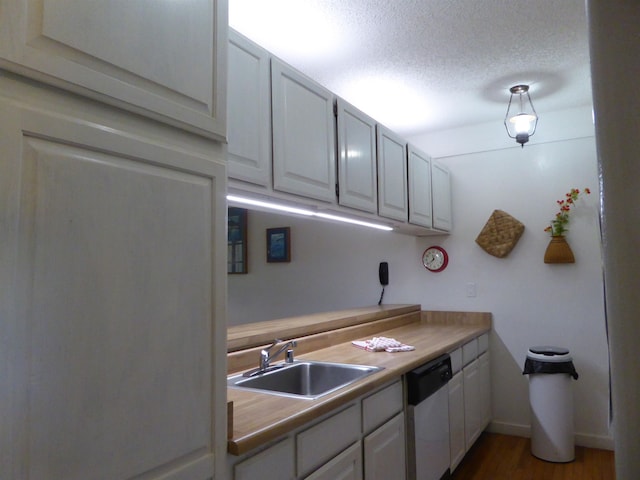 kitchen with a textured ceiling, dishwasher, sink, dark hardwood / wood-style floors, and white cabinets