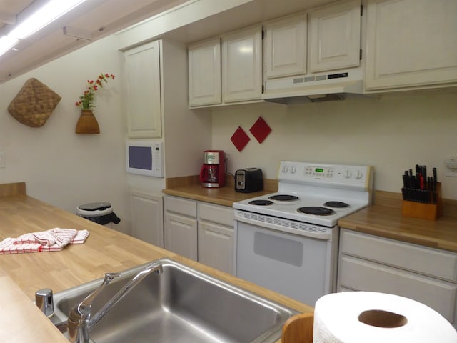 kitchen with white appliances, sink, white cabinets, and butcher block countertops