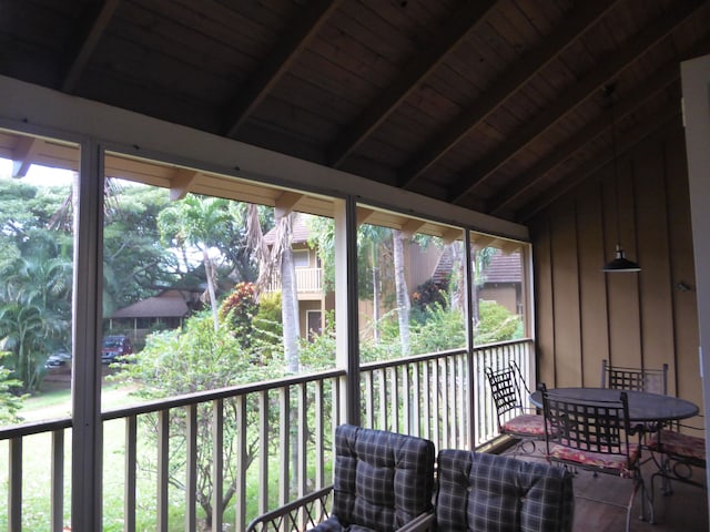 sunroom / solarium featuring plenty of natural light, wooden ceiling, and vaulted ceiling with beams