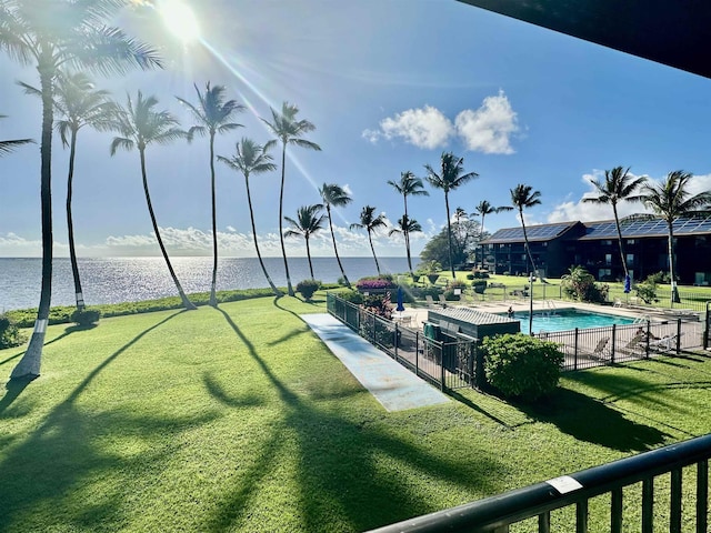 view of community featuring a yard, a water view, and a swimming pool