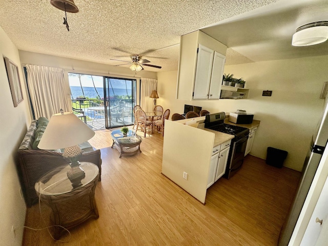 kitchen with light hardwood / wood-style floors, white cabinetry, ceiling fan, and black range with gas cooktop