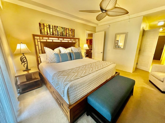 bedroom with ceiling fan, a fireplace, and light carpet