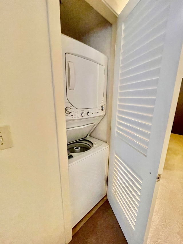 clothes washing area featuring carpet flooring and stacked washer / drying machine