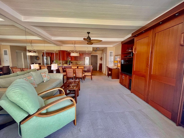 living room featuring light carpet, beamed ceiling, and ceiling fan