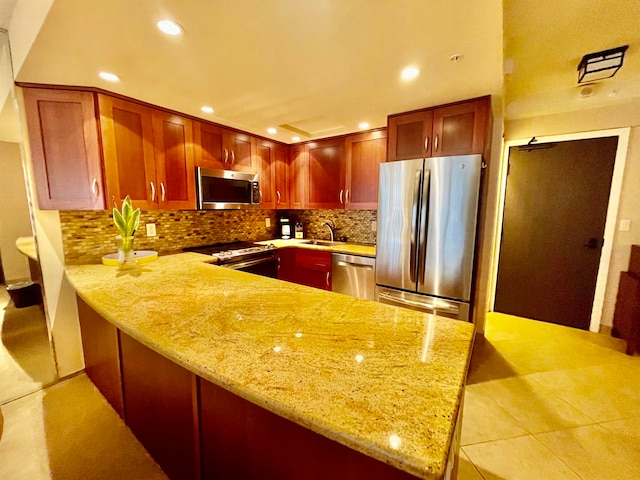 kitchen with tasteful backsplash, light tile patterned flooring, stainless steel appliances, light stone countertops, and kitchen peninsula