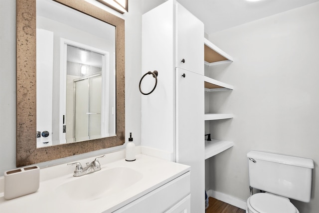 bathroom featuring vanity, wood-type flooring, an enclosed shower, and toilet